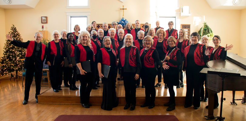 the choir, dressed in black clothes and red vests, ready to perform the Christmas concert.